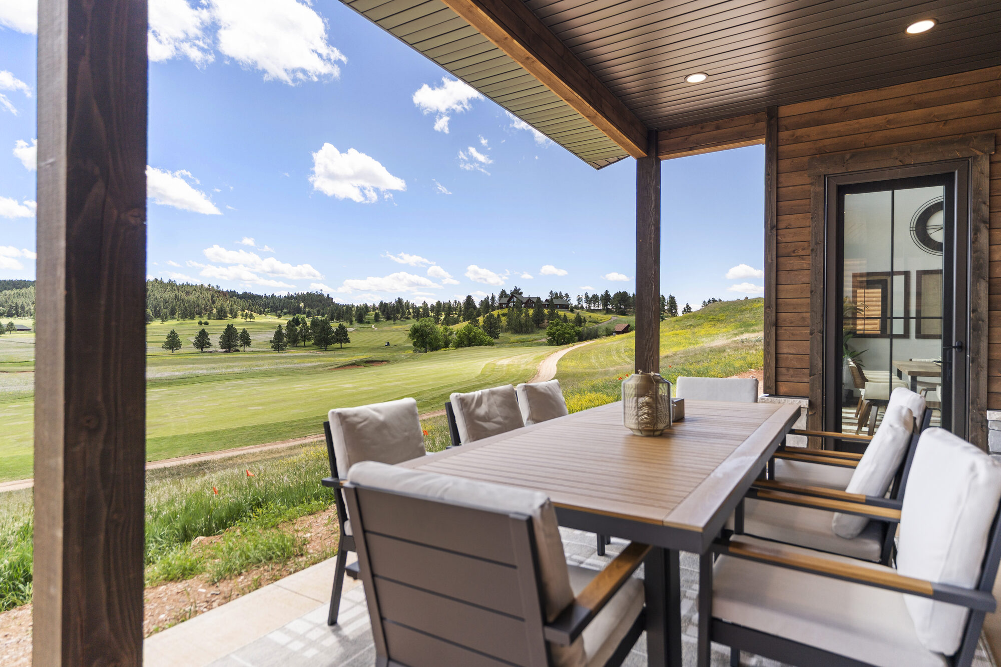 A covered outdoor living porch overlooking the golf course at The Golf Club at Devils Tower