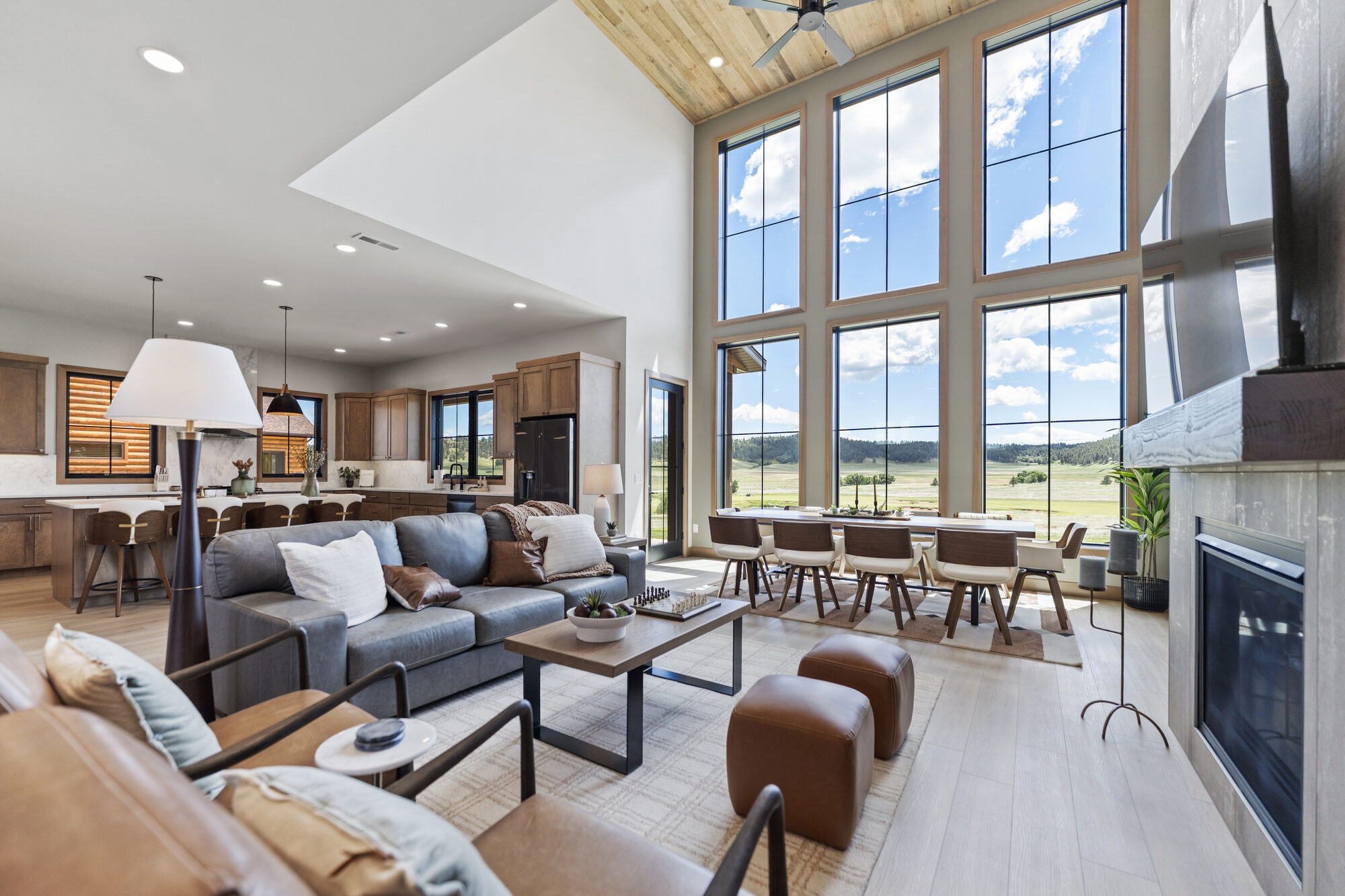 A great room with wood-beam ceiling and floor-to-ceiling windows in a home at The Golf Club at Devils Tower