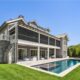 Rear view of house featuring a yard, a sunroom, an outdoor living space, and a patio area